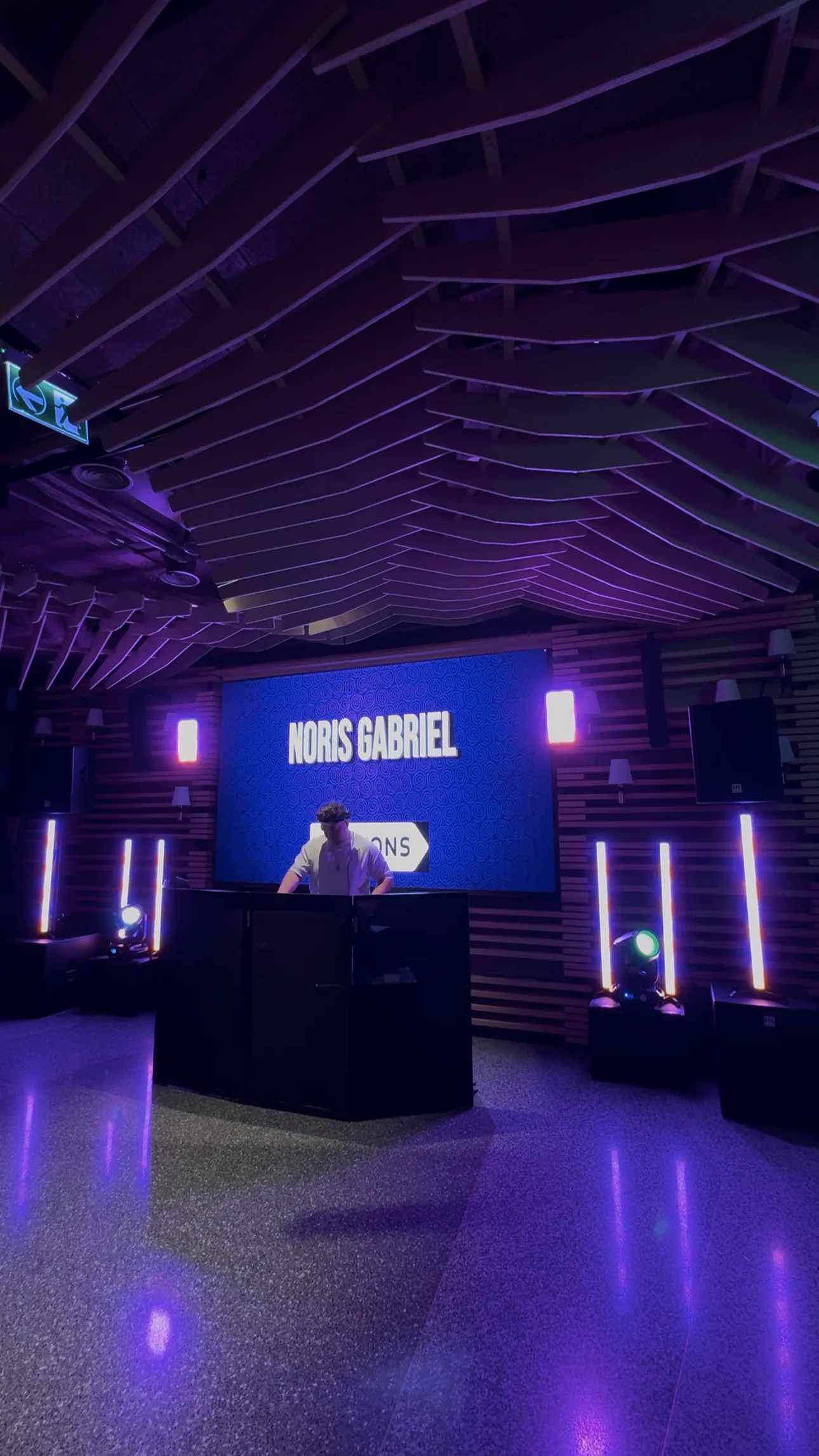 DJ la pupitru, alături de echipamente și lumini violet